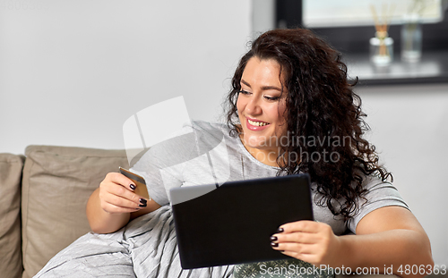 Image of woman with tablet pc and credit card at home