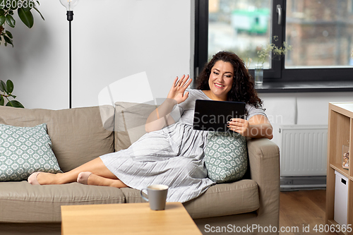 Image of woman with tablet pc having video chat at home