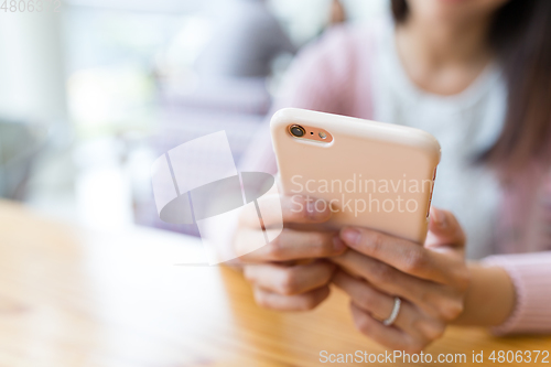 Image of Woman using cellphone in restaurant