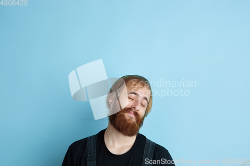 Image of Portrait of young caucasian man looks dreamful and happy