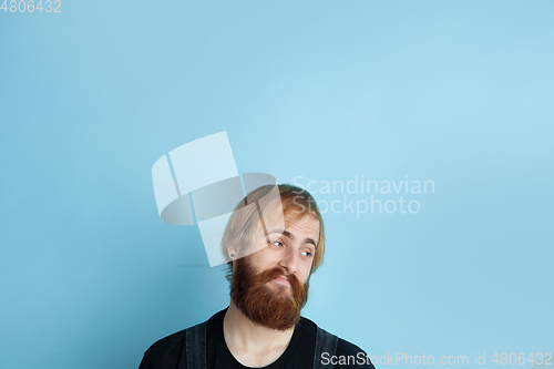 Image of Portrait of young caucasian man looks dreamful and happy