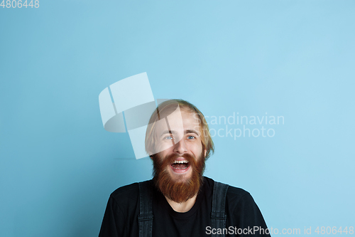 Image of Portrait of young caucasian man looks dreamful and happy