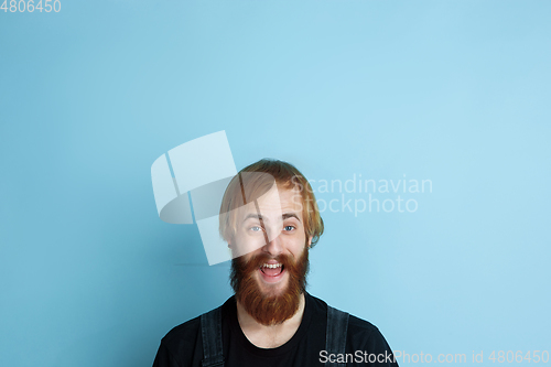 Image of Portrait of young caucasian man looks dreamful and happy