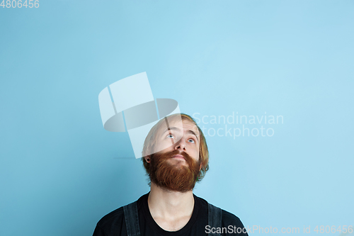 Image of Portrait of young caucasian man looks dreamful and happy