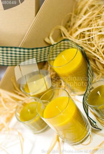 Image of yellow candles, ribbon and box