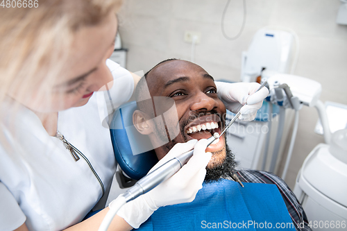 Image of Young african-american man visiting dentist\'s office, smiling