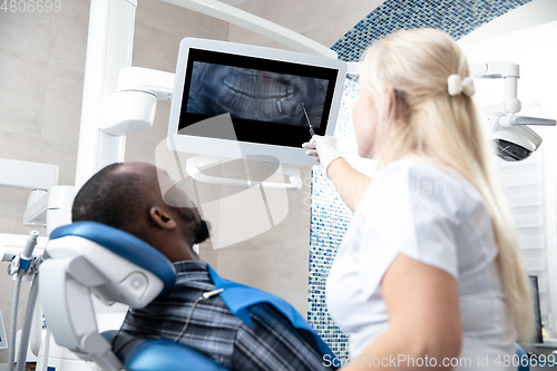 Image of Young african-american man visiting dentist\'s office