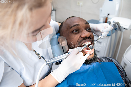 Image of Young african-american man visiting dentist\'s office, smiling