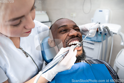 Image of Young african-american man visiting dentist\'s office, smiling