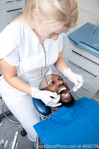 Image of Young african-american man visiting dentist\'s office