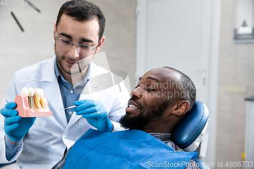 Image of Young african-american man visiting dentist\'s office