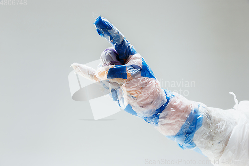 Image of Big plastic hand made of garbage isolated on white studio background