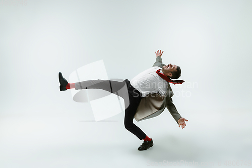 Image of Young caucasian man moving flexible on white studio background