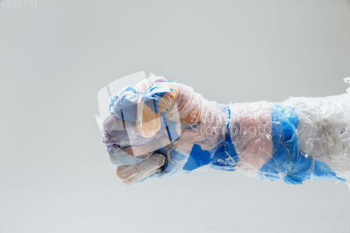 Image of Big plastic hand made of garbage isolated on white studio background