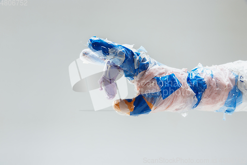 Image of Big plastic hand made of garbage isolated on white studio background