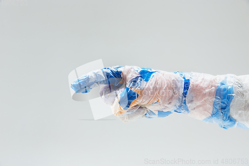 Image of Big plastic hand made of garbage isolated on white studio background