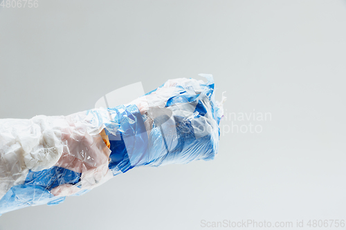 Image of Big plastic hand made of garbage isolated on white studio background