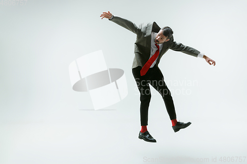 Image of Young caucasian man moving flexible on white studio background