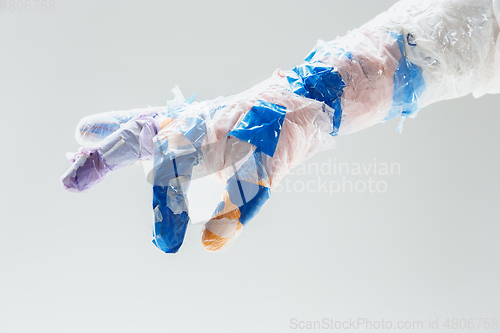 Image of Big plastic hand made of garbage isolated on white studio background