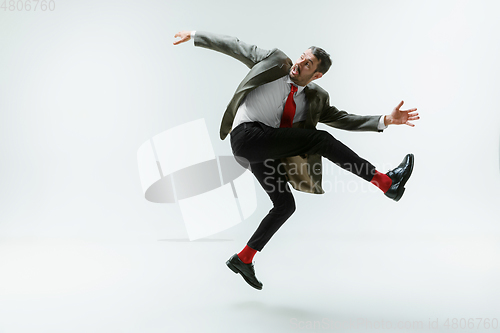 Image of Young caucasian man moving flexible on white studio background