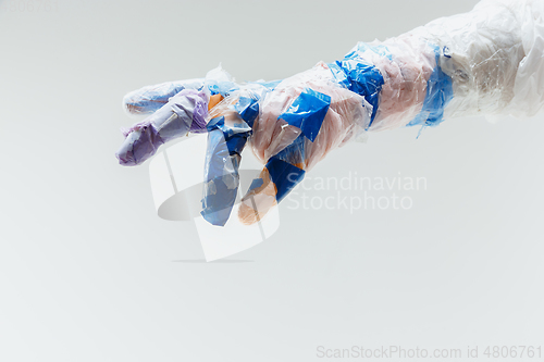 Image of Big plastic hand made of garbage isolated on white studio background