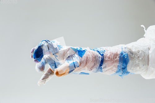 Image of Big plastic hand made of garbage isolated on white studio background