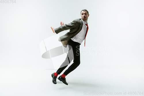 Image of Young caucasian man moving flexible on white studio background