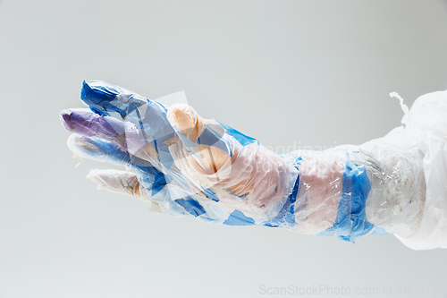 Image of Big plastic hand made of garbage isolated on white studio background