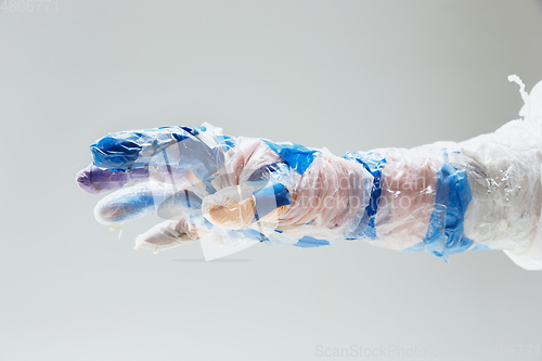 Image of Big plastic hand made of garbage isolated on white studio background