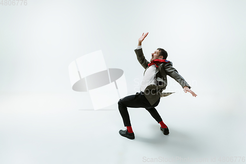 Image of Young caucasian man moving flexible on white studio background