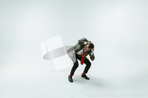 Image of Young caucasian man moving flexible on white studio background