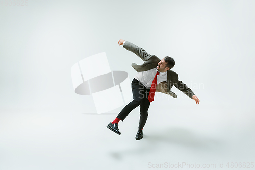 Image of Young caucasian man moving flexible on white studio background