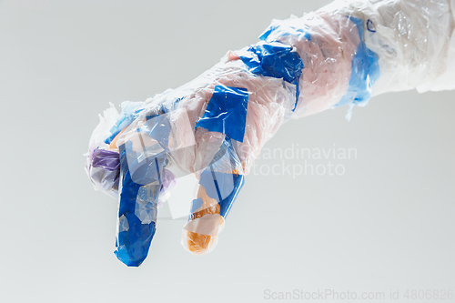 Image of Big plastic hand made of garbage isolated on white studio background
