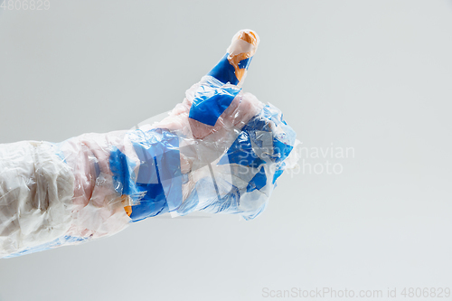 Image of Big plastic hand made of garbage isolated on white studio background