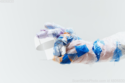 Image of Big plastic hand made of garbage isolated on white studio background