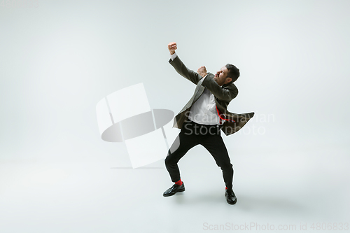 Image of Young caucasian man moving flexible on white studio background