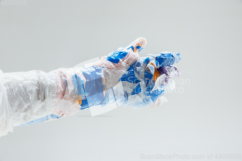 Image of Big plastic hand made of garbage isolated on white studio background