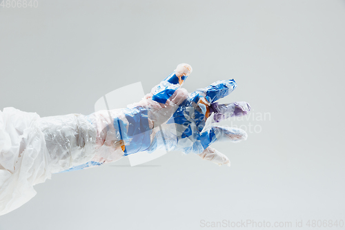 Image of Big plastic hand made of garbage isolated on white studio background