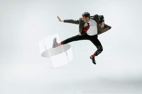 Image of Young caucasian man moving flexible on white studio background