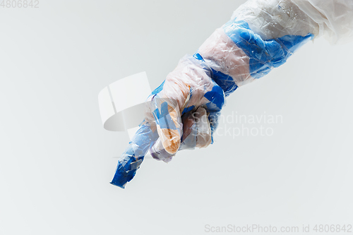 Image of Big plastic hand made of garbage isolated on white studio background