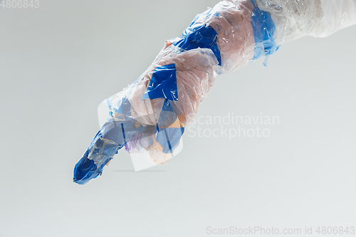 Image of Big plastic hand made of garbage isolated on white studio background