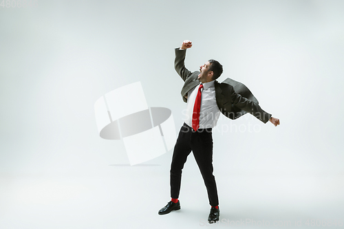 Image of Young caucasian man moving flexible on white studio background