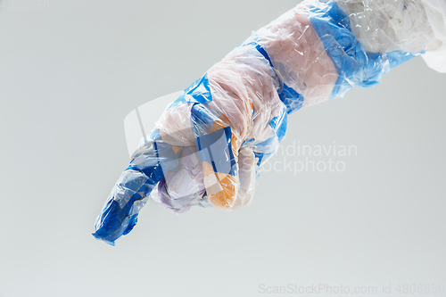 Image of Big plastic hand made of garbage isolated on white studio background