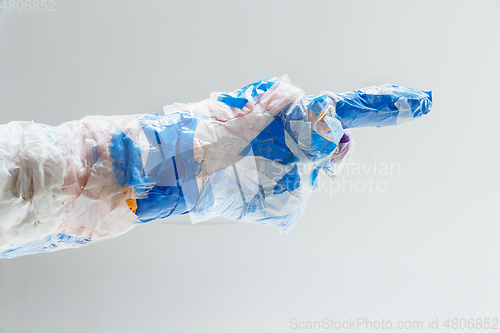 Image of Big plastic hand made of garbage isolated on white studio background