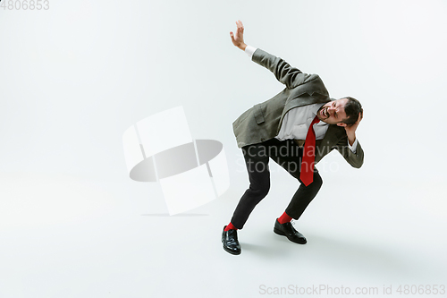 Image of Young caucasian man moving flexible on white studio background