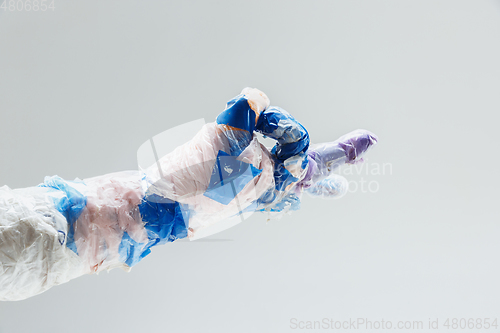 Image of Big plastic hand made of garbage isolated on white studio background