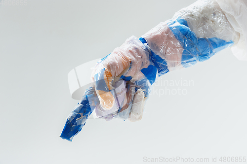 Image of Big plastic hand made of garbage isolated on white studio background