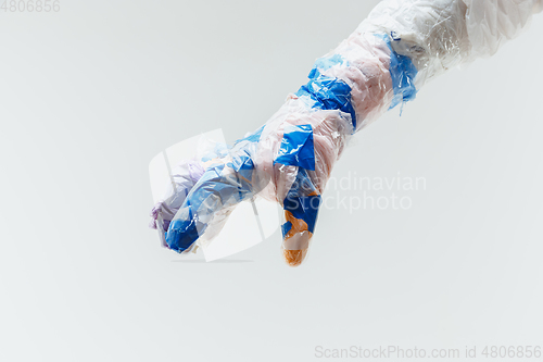 Image of Big plastic hand made of garbage isolated on white studio background