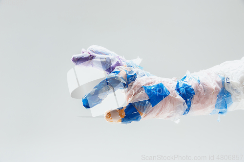 Image of Big plastic hand made of garbage isolated on white studio background