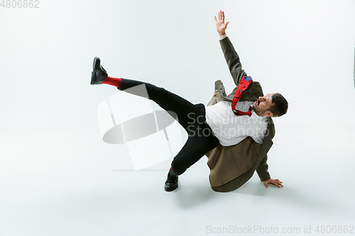 Image of Young caucasian man moving flexible on white studio background